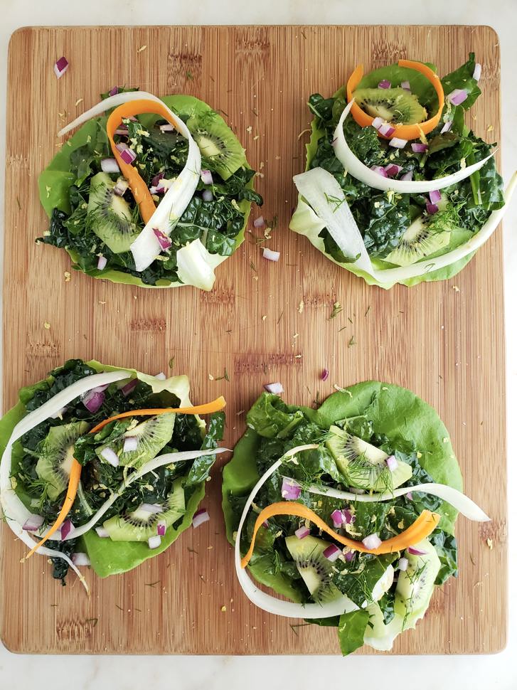 Kale lettuce wraps on a wood cutting board.