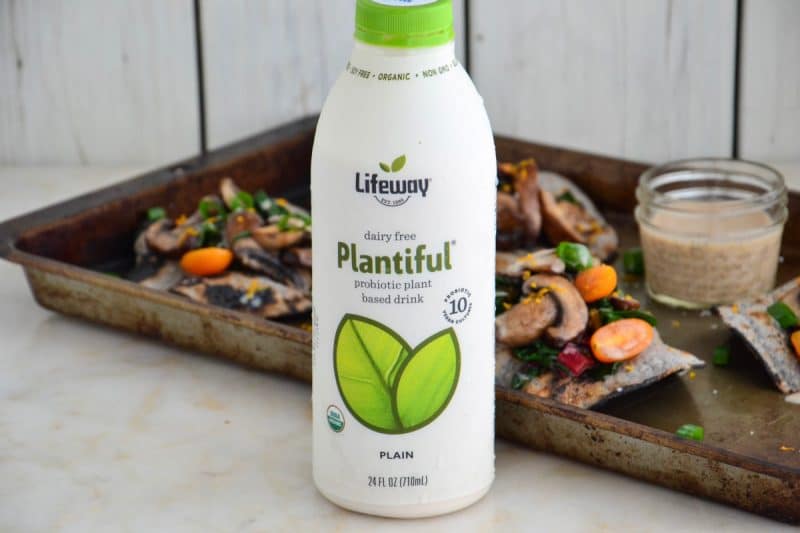 Lifeway Kefir Plantiful plain drink in front of a baking sheet with veggie fajitas.