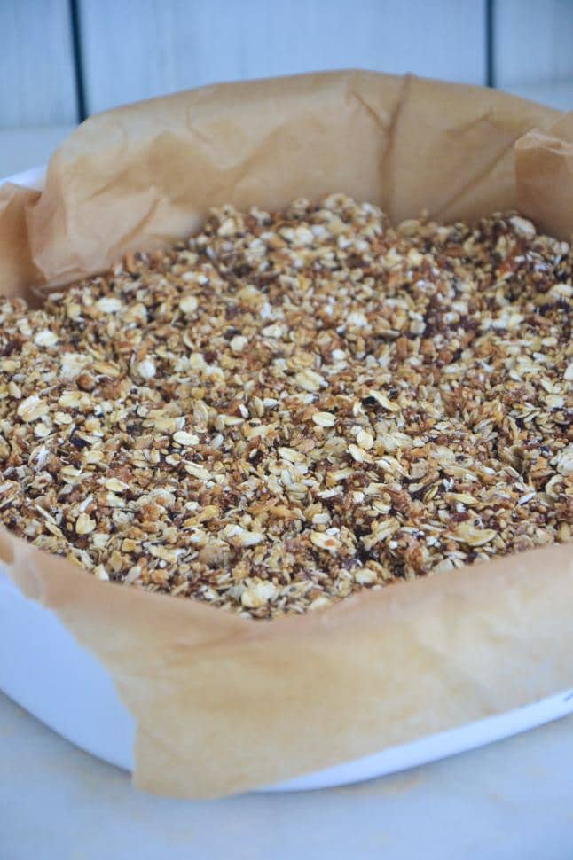 Apricot coconut bars in a white baking dish on a marble table.