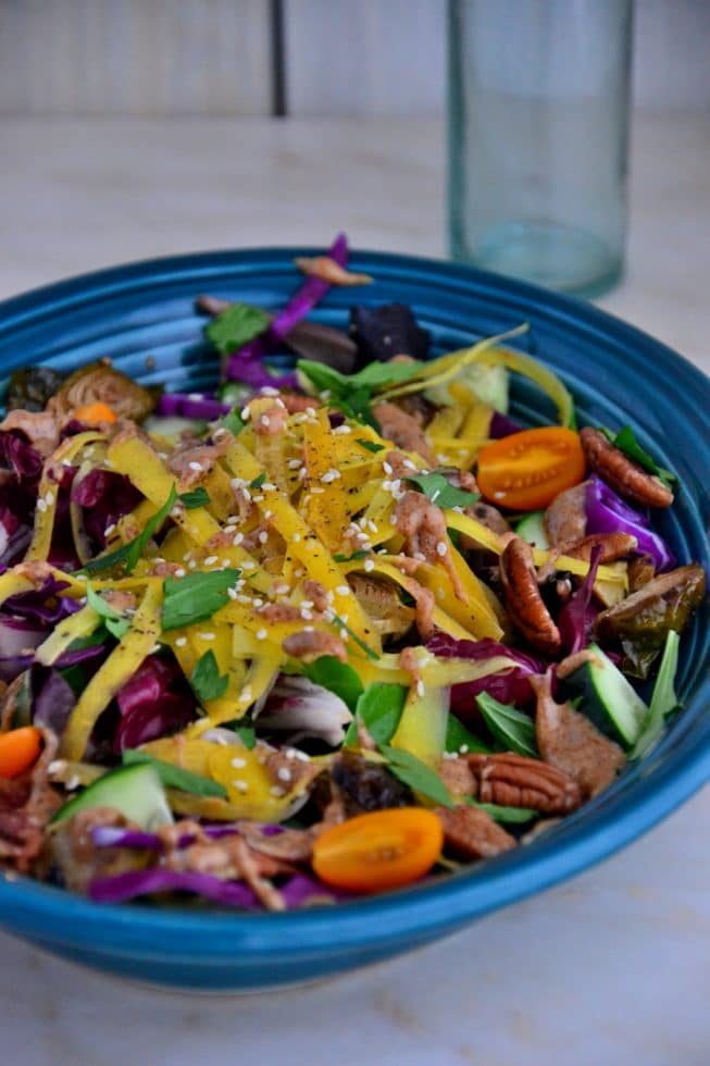 Simple Yellow Carrot and Brussel Sprout Salad with salad greens, sweet cherry tomatoes and pecans!