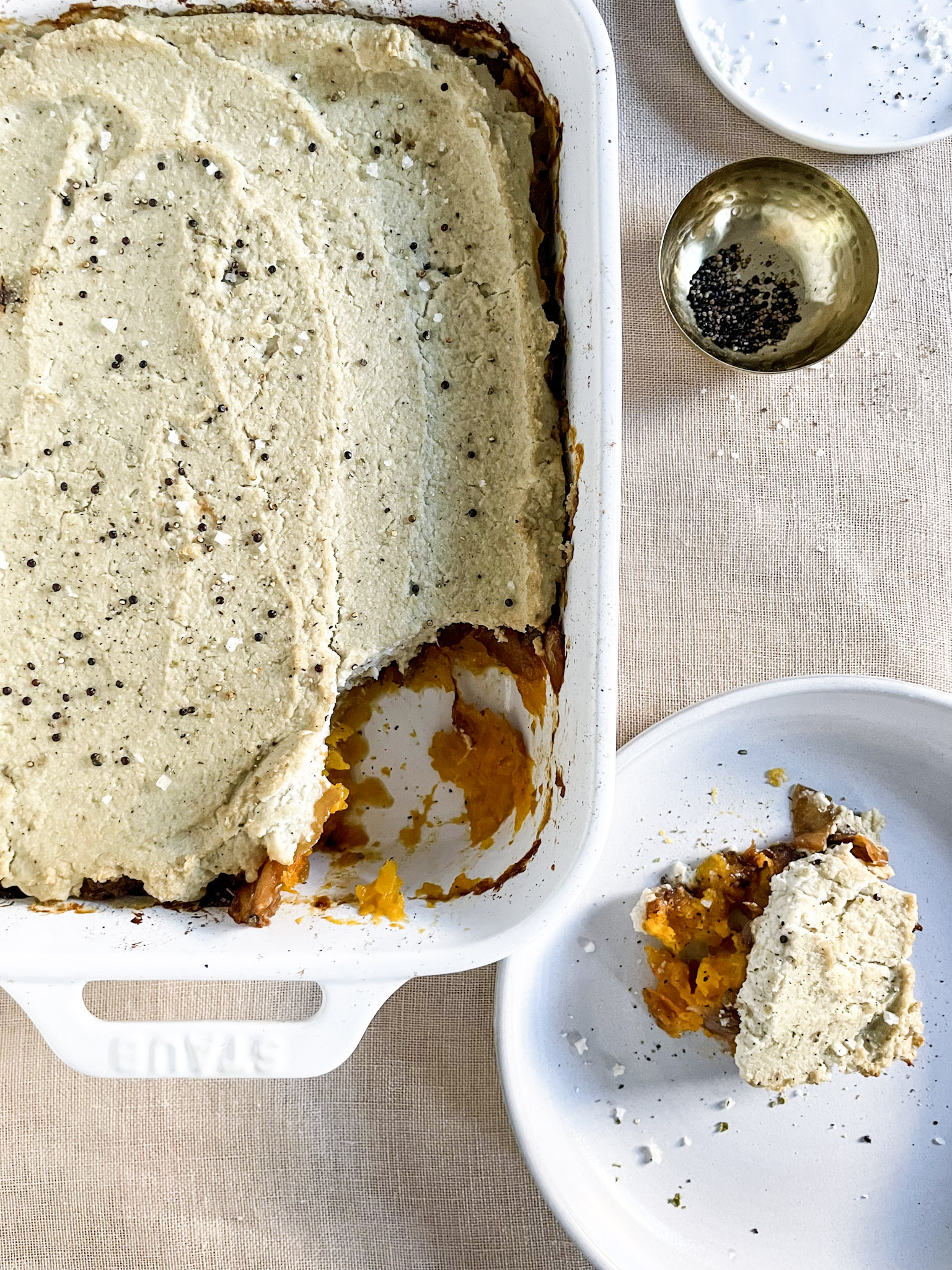 Cauliflower + Butternut Squash Bake with Caramelized Onions in a White Baking Dish