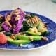 Easy massaged kale salad on a blue plate with avocado, grapefruit and walnuts.