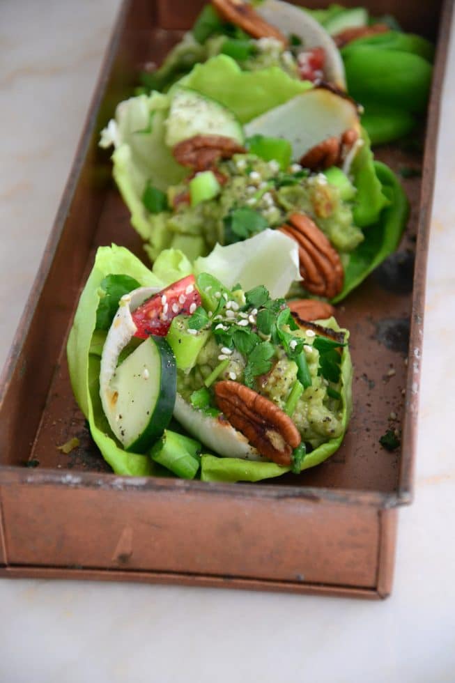 Vegetarian Lettuce Wraps filled with red bell pepper, cucumbers, guacamole and pecans!