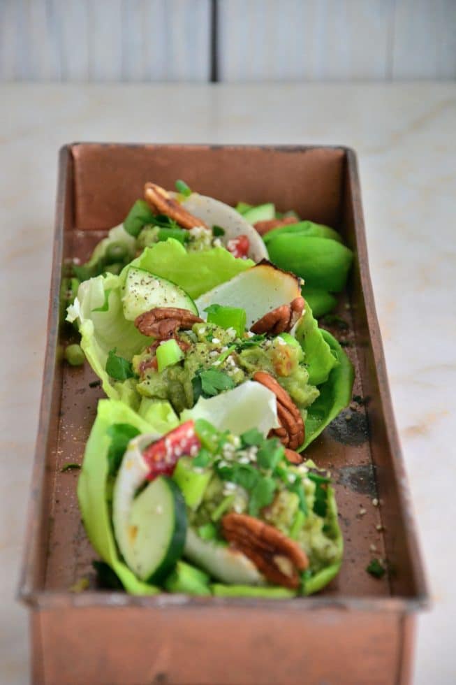 Vegetarian Lettuce Wraps on a gorgeous copper platter filled with guacamole, scallions, cucumbers and red bell peppers!