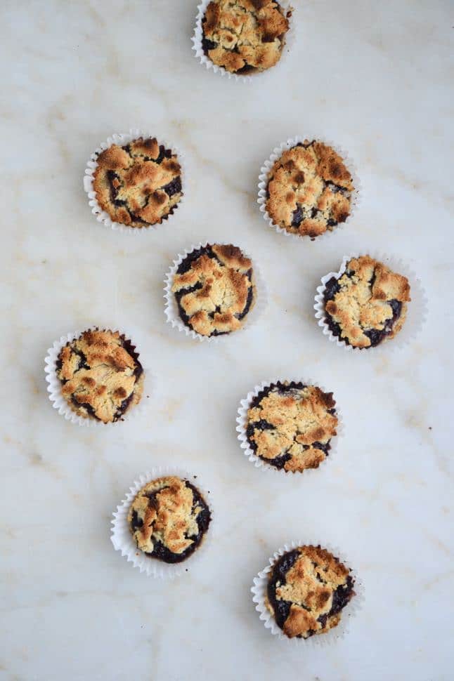 An overhead shot of a bunch of perfectly browned muffins in muffin tins on a counter.