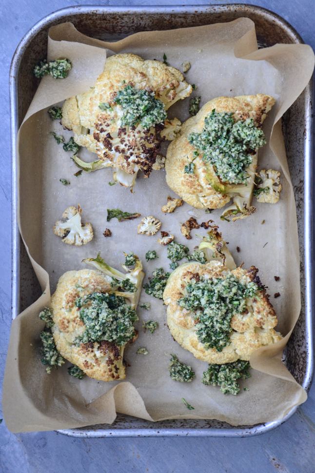 Heaping spoonfuls of gluten-free pesto on top of chunks of roasted cauliflower