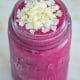 Red velvet beet smoothie in a glass jar on a marble table top.