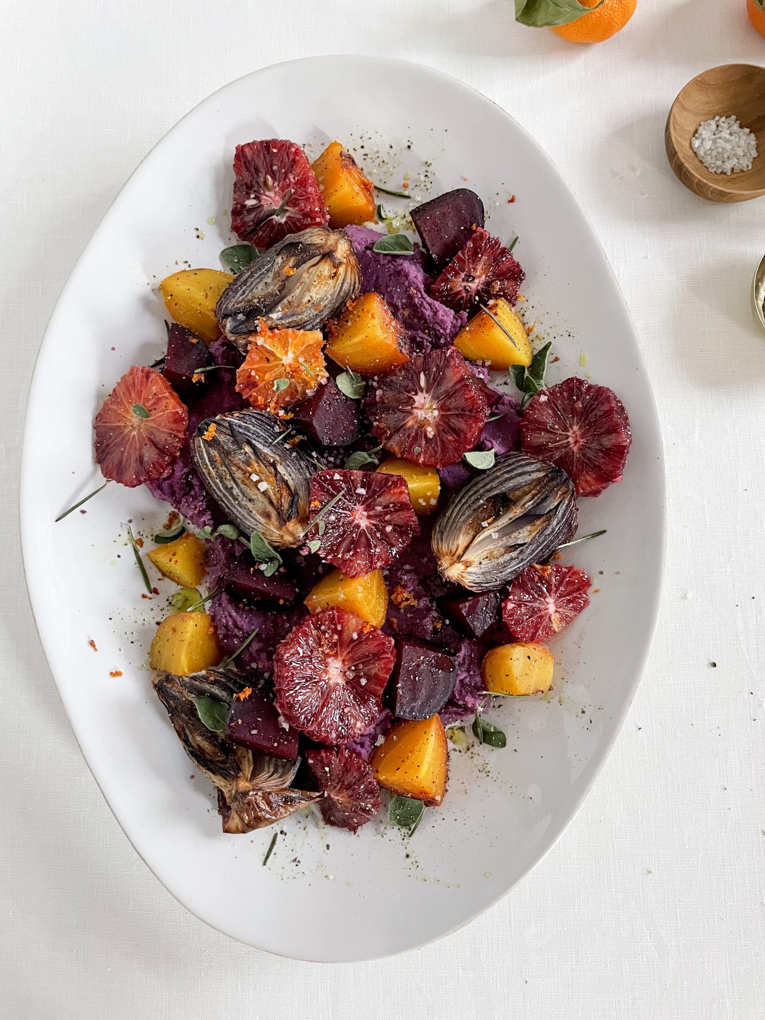 Roasted Beets + Onions with Blood Oranges on a white tablecloth and white oval platter.