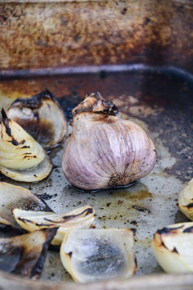 Roasted garlic hot out of the oven in a large roasting pan.
