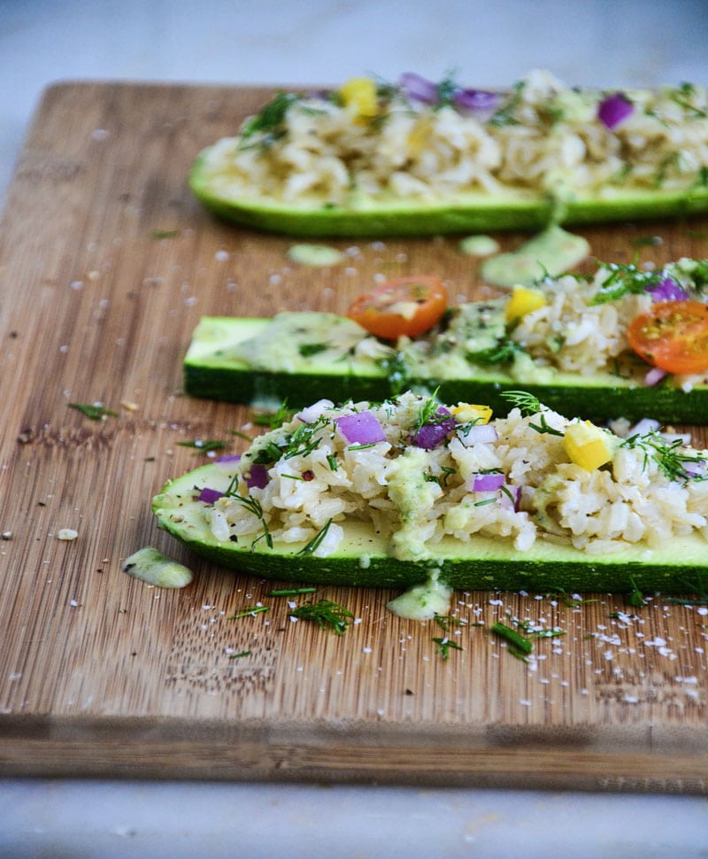 Simple Summer Zucchini Boats on a wooden cutting board.