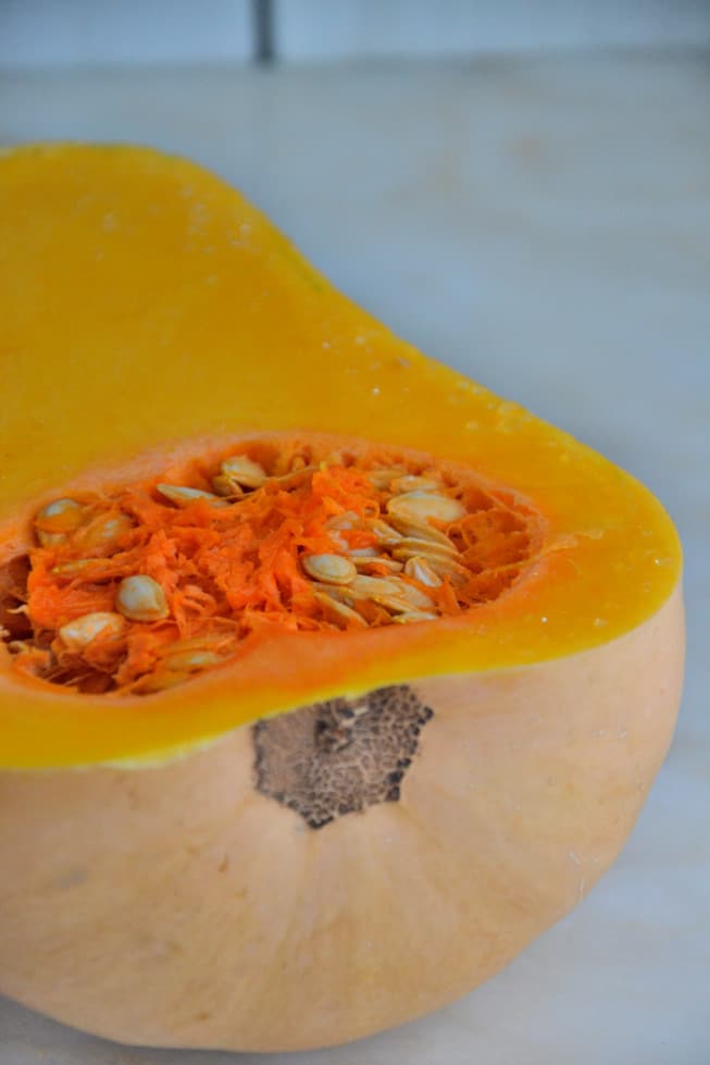 The best butternut squash soup involves slicing a butternut squash in half lengthwise.