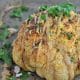 Whole Roasted Cauliflower recipes warm and toasted out of the oven served with cashews and tahini sauce.